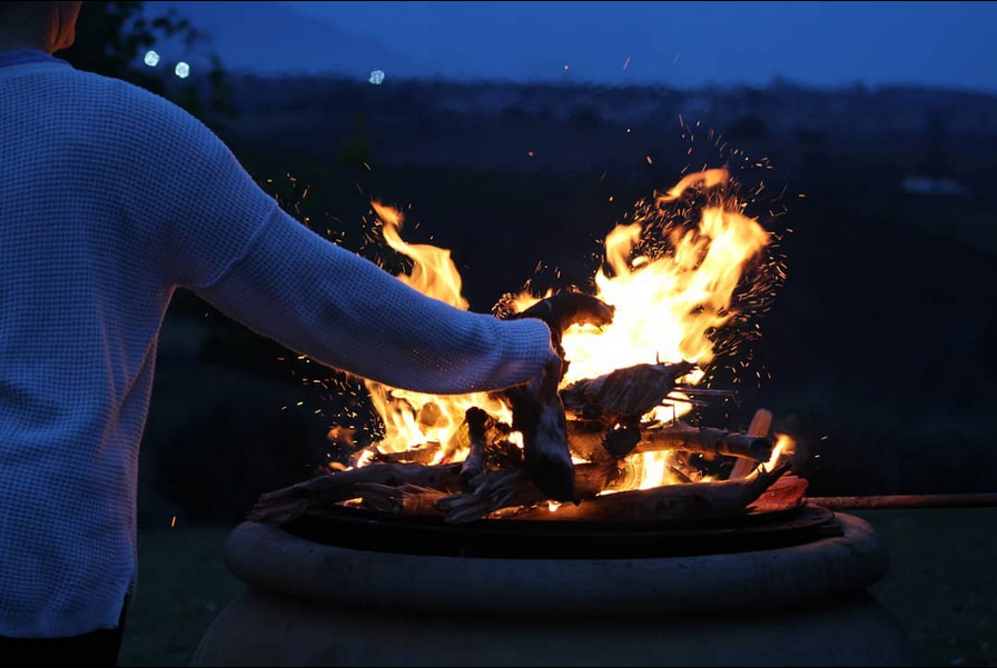 Tending the fire pit at dusk