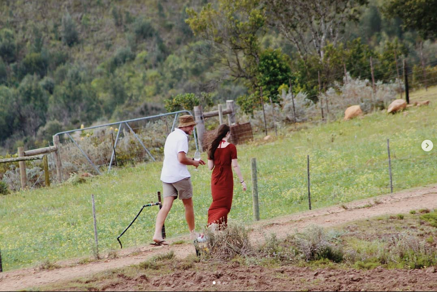 Couple walking on a farm road with green hills