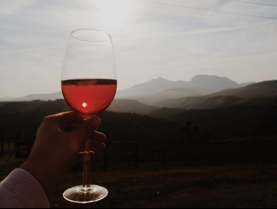 Wine glass silhouette against a mountain sunset